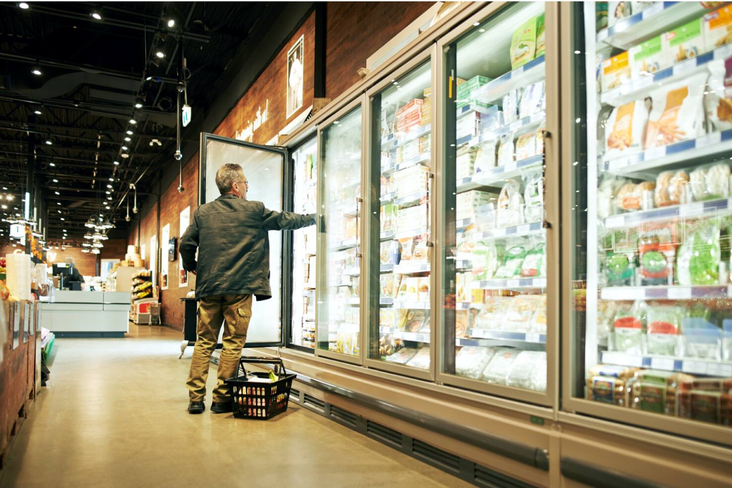 Man taking out cold stored food item from refrigerator in mall