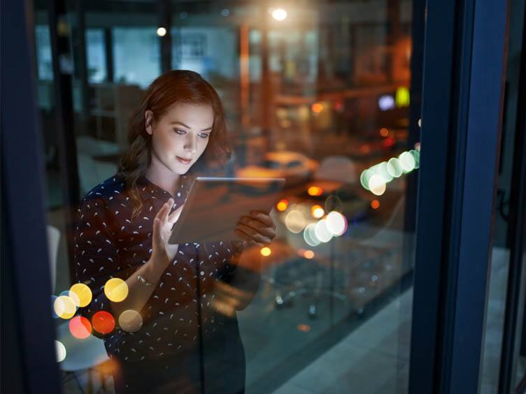 A woman standing and scrolling on a tab
