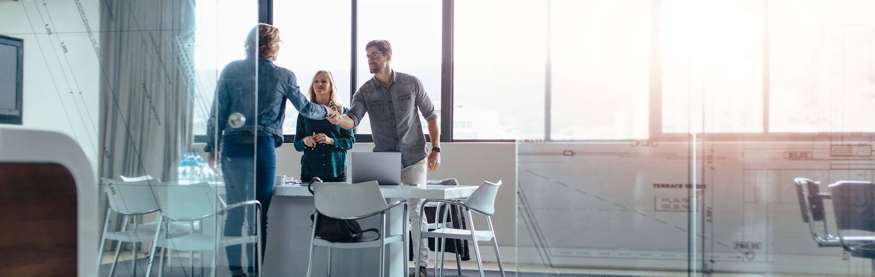 Three people are discussing in a meeting room