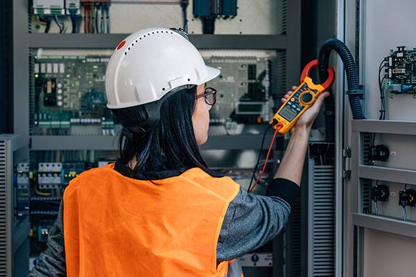 Workers wearing hardhats walking through air handler units talking